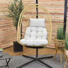 Load image into Gallery viewer, Front view of the Cappuccino Deluxe Nest Chair with steel stand in a timber-panelled room.