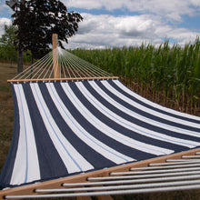 Load image into Gallery viewer, Harbour double Sunbrella® quilted hammock stretched open outdoors beside a cornfield.