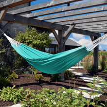 Load image into Gallery viewer, Turquoise Aruba double Sunbrella hammock suspended beneath a wooden pergola in a garden