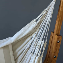 Load image into Gallery viewer, Close-up of the cream hanging chair’s woven fabric, braided edging and suspension cords beside the timber fram