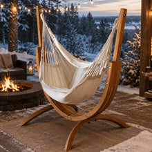Load image into Gallery viewer, Coastal Lounger timber stand with a cream hammock chair on a patio beside a fire pit
