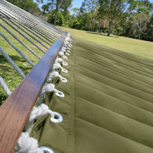 Load image into Gallery viewer, Close-up of the olive quilted hammock bed, wooden spreader bar, metal eyelets and white suspension cords
