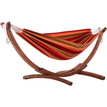 Load image into Gallery viewer, Sunset double Sunbrella® hammock with red, orange and gold stripes on a curved pine stand against a white background.