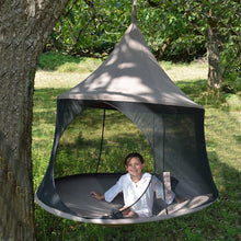 Load image into Gallery viewer, Child sitting inside a Taupe Cacoon Reto suspended from a tree in a grassy garden.