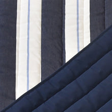 Load image into Gallery viewer, Close-up of Harbour navy and white striped fabric with the navy quilted underside folded back.